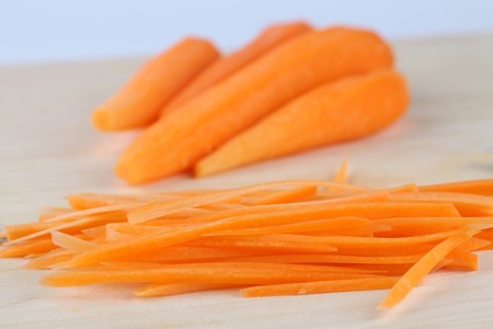 Slices of fresh organic carrot on cutting boardの写真素材