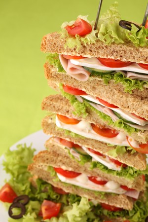 Healthy sandwiches with ham, camembert, tomatoes, cucumber, lettuce and black olivesの写真素材