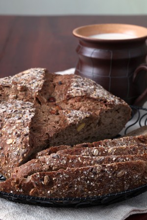 Loaf of wholemeal bread with slices and milkの写真素材