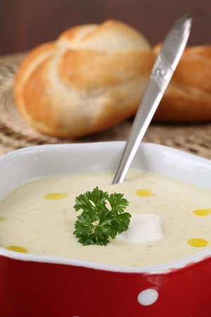 Vegetable cream soup made of carrot, potato, broccoli, green beans, parsley and creamの写真素材