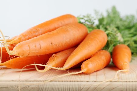 Bunch of fresh organic carrots on cutting boardの写真素材