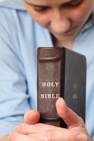 Young woman holding the Bible and prayingの素材 [FY3107076564]