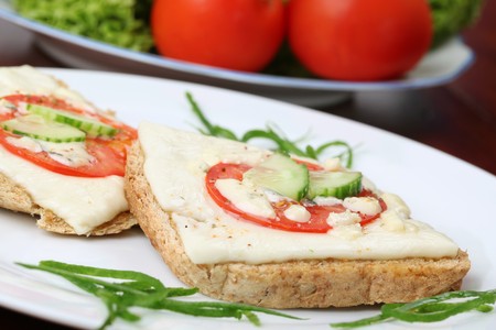 Grilled cheese and tomato sandwiches garnished with fresh cucumberの写真素材