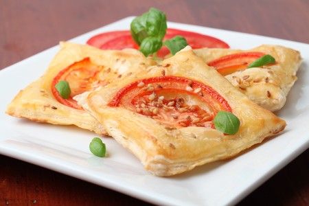 Puff pastry with cheese and tomatoes seasoned with sesame seedsの写真素材