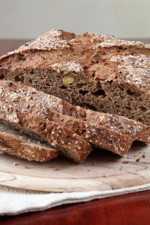 Loaf of wholemeal bread with slices on cutting boardの写真素材
