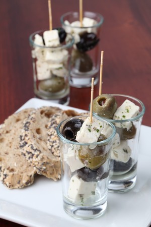 Greek appetizers in small glasses with black and green olives and feta cheeseの写真素材