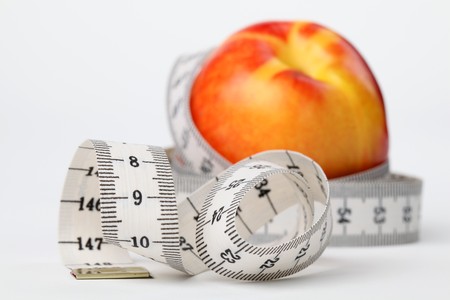 Tape measure and nectarine. Focus on tape measureの写真素材
