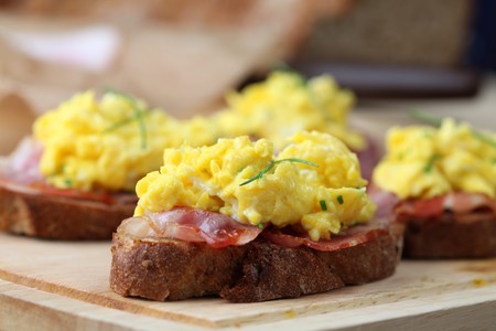 Sandwiches with scrambled eggs and bacon, garnished with chives.の写真素材