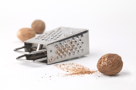 Nutmegs and grater on white background. Shallow dofの写真素材