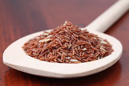 Close-up of a wooden spoon with red rice. Shallow dofの写真素材