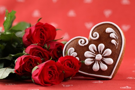 Gingerbread heart and red roses on red background. Shallow dofの写真素材