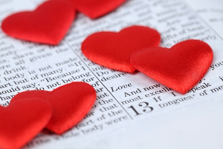 Bible open to 1st Corinthians 13, a passage about love, and little heart shaped confetti. Shallow dofの写真素材