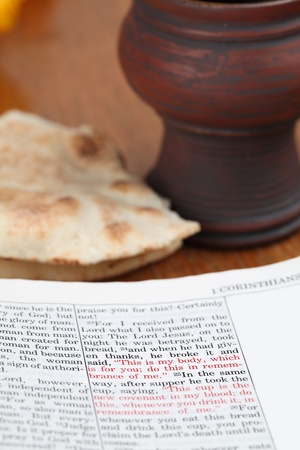 Bible open to 1 Corinthians 11 with selective focus on the text about the Last Supper. All copyright...