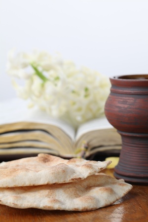 Communion. Chalice with red wine, pita bread, Holy Bible and white hyacinthの写真素材