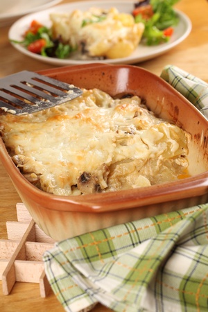 Potato gratin with mushrooms, eggs, cheese and mixed greensの写真素材