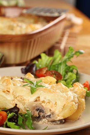 Potato gratin with mushrooms, eggs, cheese and mixed greensの写真素材