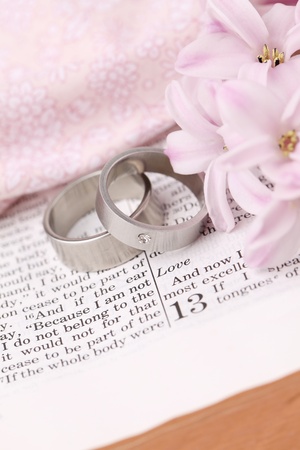 Titanium wedding rings on the Bible open to 1st Corinthians 13, a passage about love  Shallow dofの写真素材