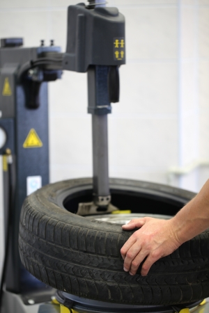 Car mechanic changing a tire in a car serviceの写真素材