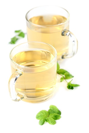 Mint leaf and freshly made mint tea in glass cups isolated on white background  Shallow dof, focus on mintの写真素材
