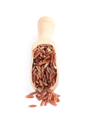 Wooden spoon with red rice on white backgroundの写真素材