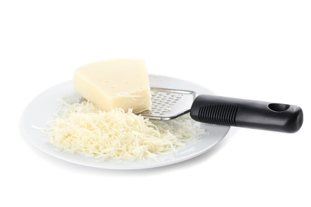 Grated cheese and grater on a plate isolated on white backgroundの写真素材