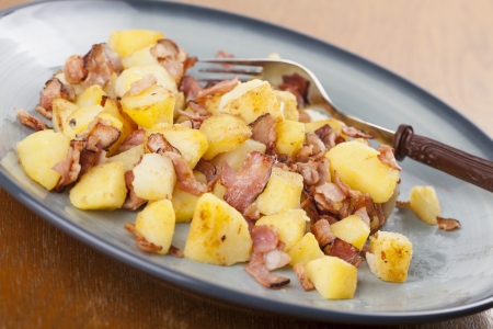 Roasted potatoes with crispy bacon on a plateの写真素材