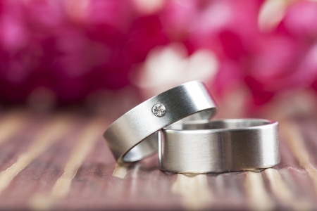 Titanium wedding rings with red hyacinth in the background  Shallow dofの写真素材
