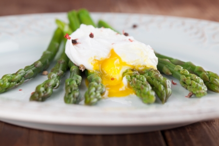 Green asparagus with poached egg on a plateの写真素材
