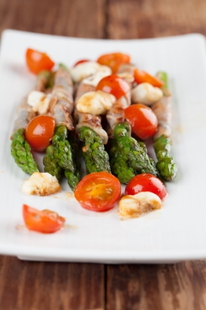 Grilled asparagus with prosciutto, mozzarella and cherry tomatoesの写真素材