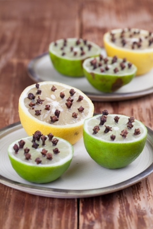 Lemon and limes with cloves - natural insect repellent on platesの写真素材