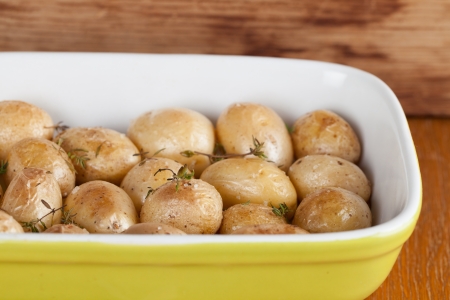 Roasted baby potatoes with thyme, olive oil and salt on baking sheetの写真素材