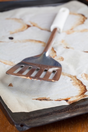 Spatula on empty baking sheet with baking paperの写真素材