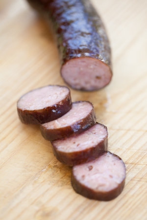 Right from a smokehouse, still warm and juicy sausage on a cutting boardの写真素材