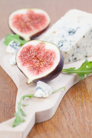 Blue cheese and fresh figs on a cutting boardの写真素材