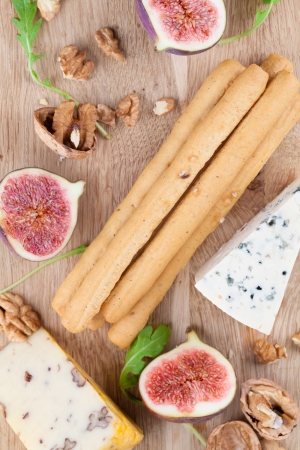 Cheese board with blue cheese, nut cheese, fresh figs, nuts and grissiniの写真素材