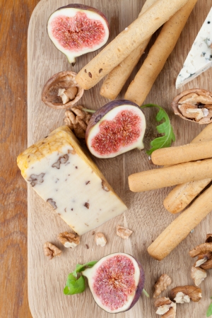 Cheese board with blue cheese, nut cheese, fresh figs, nuts and grissiniの写真素材