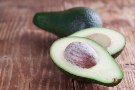 Two avocados on wooden tableの写真素材
