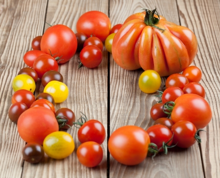 Yellow, red and black tomatoes on wooden tableの写真素材