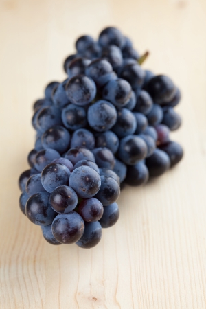 Blue grape cluster on wooden の写真素材