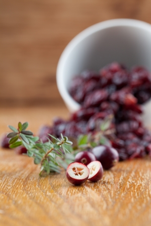 Fresh organic cranberries and a bowl with dried cranberriesの写真素材