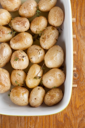 Roasted baby potatoes with thyme, olive oil and salt on baking sheetの写真素材