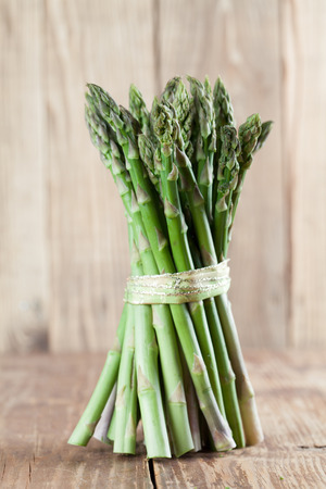 Bunch of fresh green asparagus on wooden backgroundの写真素材