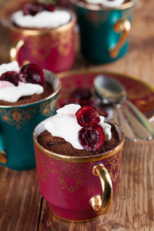Raw vegan avocado chocolate mousse with cherries and coconut whipped creamの写真素材