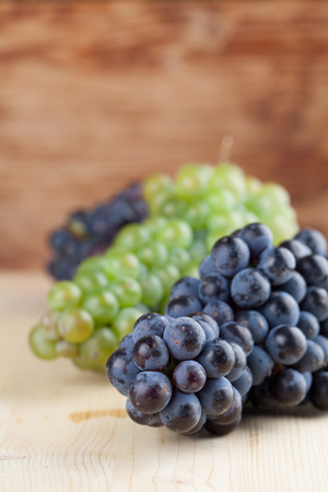 Blue and green grape clusters on wooden background  Shallow dofの写真素材