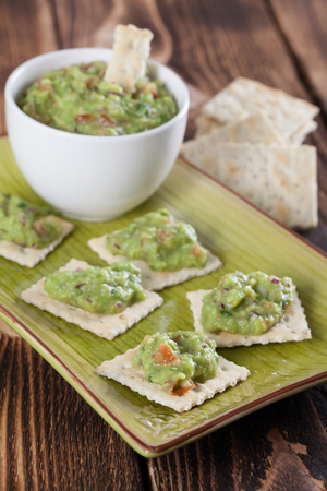 Bowl with freshly made guacamole and crackers. Shallow dofの写真素材