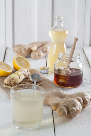 Ginger drink and the ingredients. Ginger, honey, lemon and syrup.の写真素材