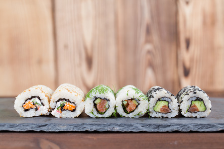 Homemade uramaki sushi rolls on a slate boardの写真素材