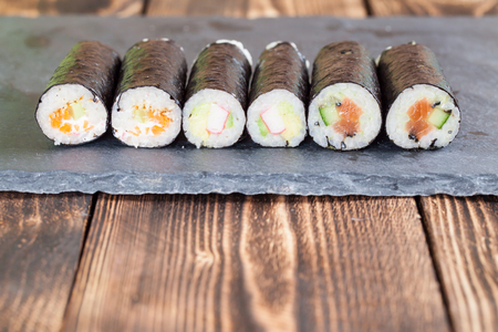 Homemade maki sushi rolls on a slate boardの写真素材