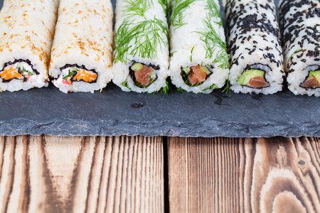 Homemade uramaki sushi rolls on a slate boardの写真素材