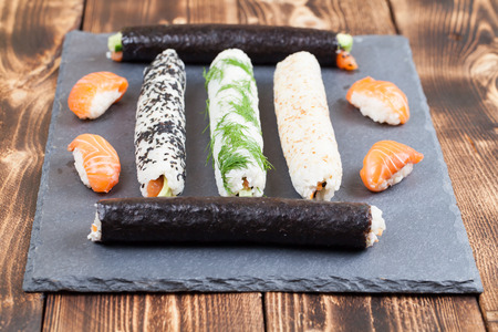 Homemade sushi rolls on a slate boardの写真素材